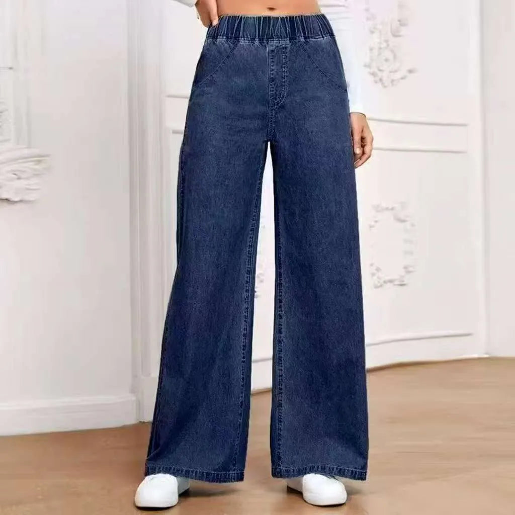 Plus size light blue washed wide-leg denim jeans on a hanger, showing straight leg cut.
