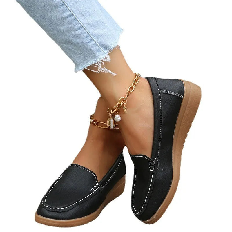 Women's flat slip-on loafers in PU leather, showing colour options and round toe design with decorative stitching.