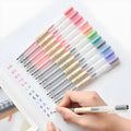 Pack of 12 black Muji gel pens with 0.5mm fine nibs on a white background