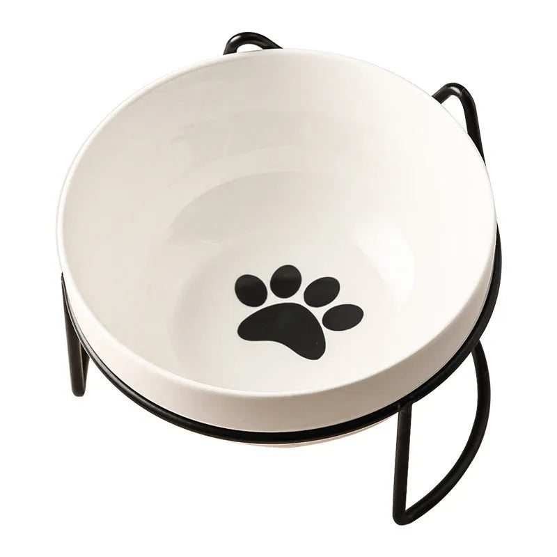 White ceramic cat food bowl with cat paw print design on black iron frame stand