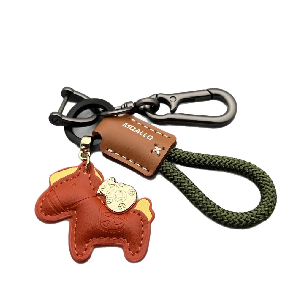 Handmade brown cowhide leather key ring with a gold pony belt buckle charm and a green flanelle rope loop.