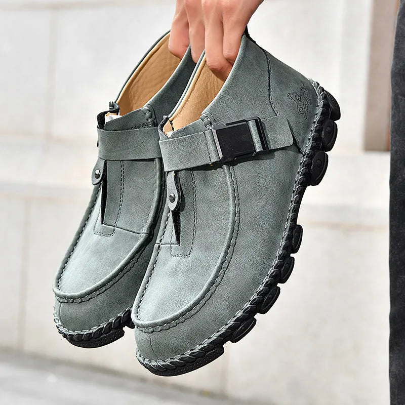 Men's black casual flat slip-on shoes with visible handmade stitching on the PU leather upper.