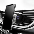 Black car phone holder attached to vehicle air vent holding smartphone