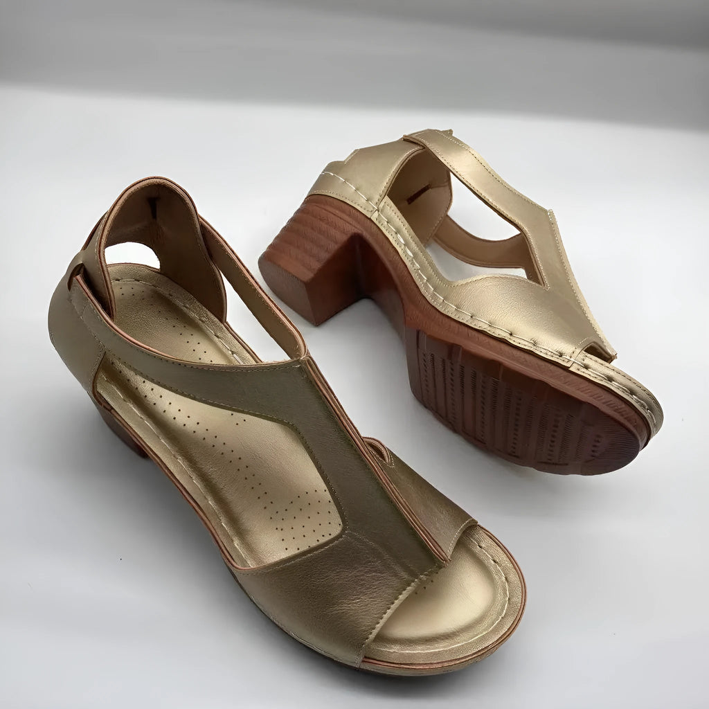 Women's beige peep toe wedge sandals with an adjustable ankle buckle strap on a foot.