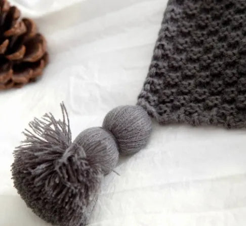 Nordic fringed knit ball acrylic blanket in beige, measuring 130 by 170 cm on a sofa.