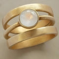 Gold plated geometric ring with micro-inlaid white chalcedony stone on a simple band.