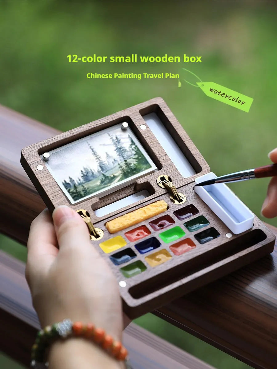 Mini walnut wood watercolour paint box open to show pigment pans inside