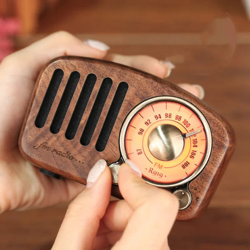 Retro wooden wireless mini Bluetooth speaker in cherry wood finish showing front speaker grille and controls