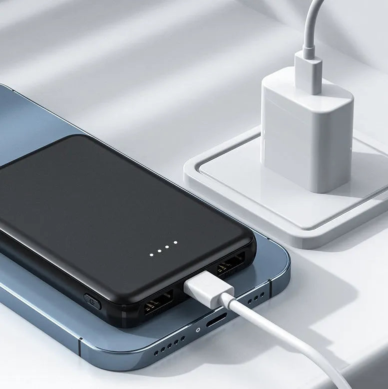 Black rectangular electric heating vest power bank with USB port, shown next to a measuring tape.