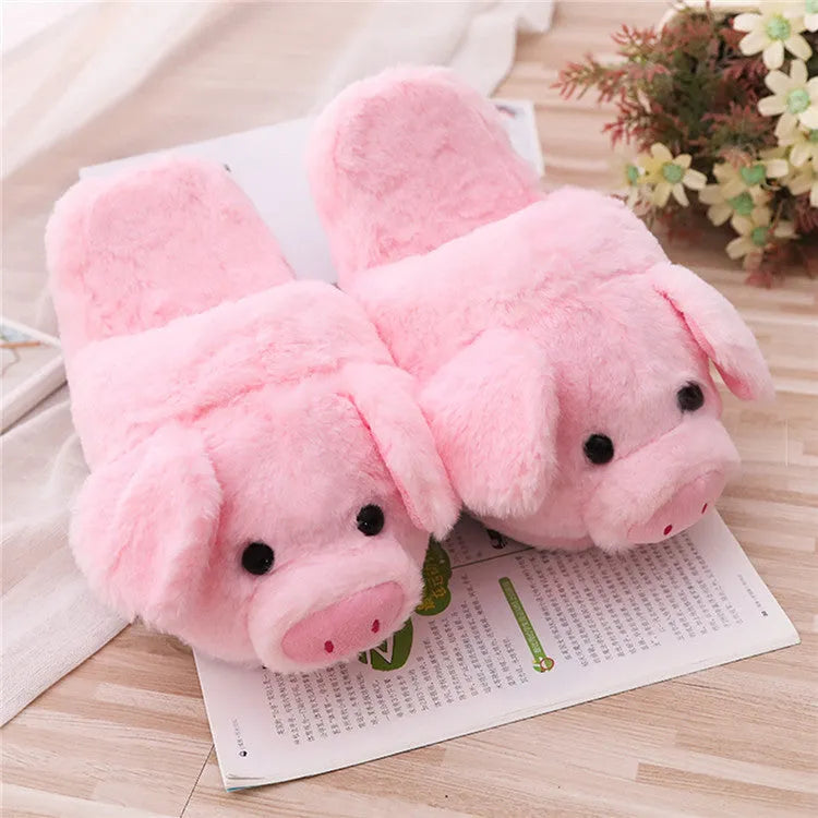 Pink pig-shaped floor slippers with a soft plush fabric exterior.