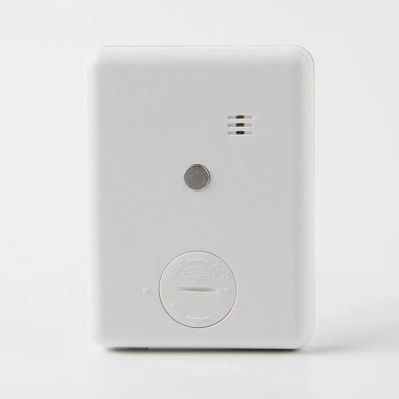 Black and white digital kitchen timer with magnetic back on a refrigerator.