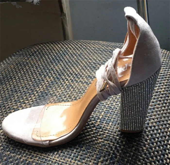 Plastic high heels with pointed toe in black and gold colours on white background
