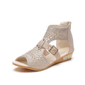 Women's beige flat sandals with a back zipper and a low wedge heel.