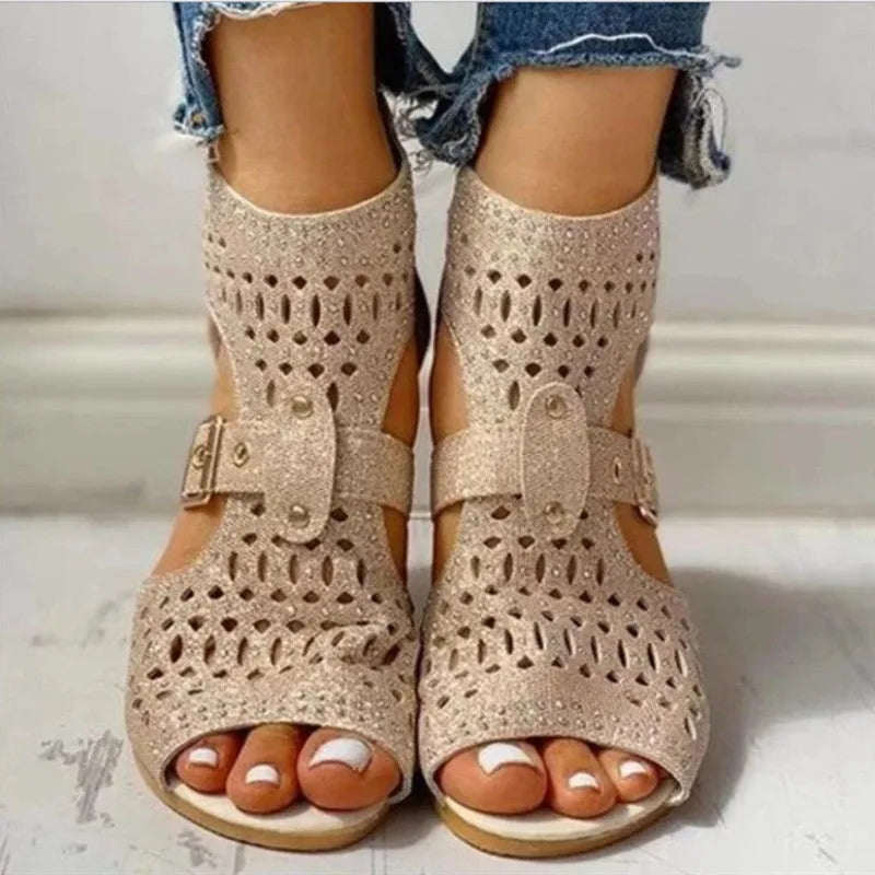 Women's beige flat sandals with a back zipper and a low wedge heel.