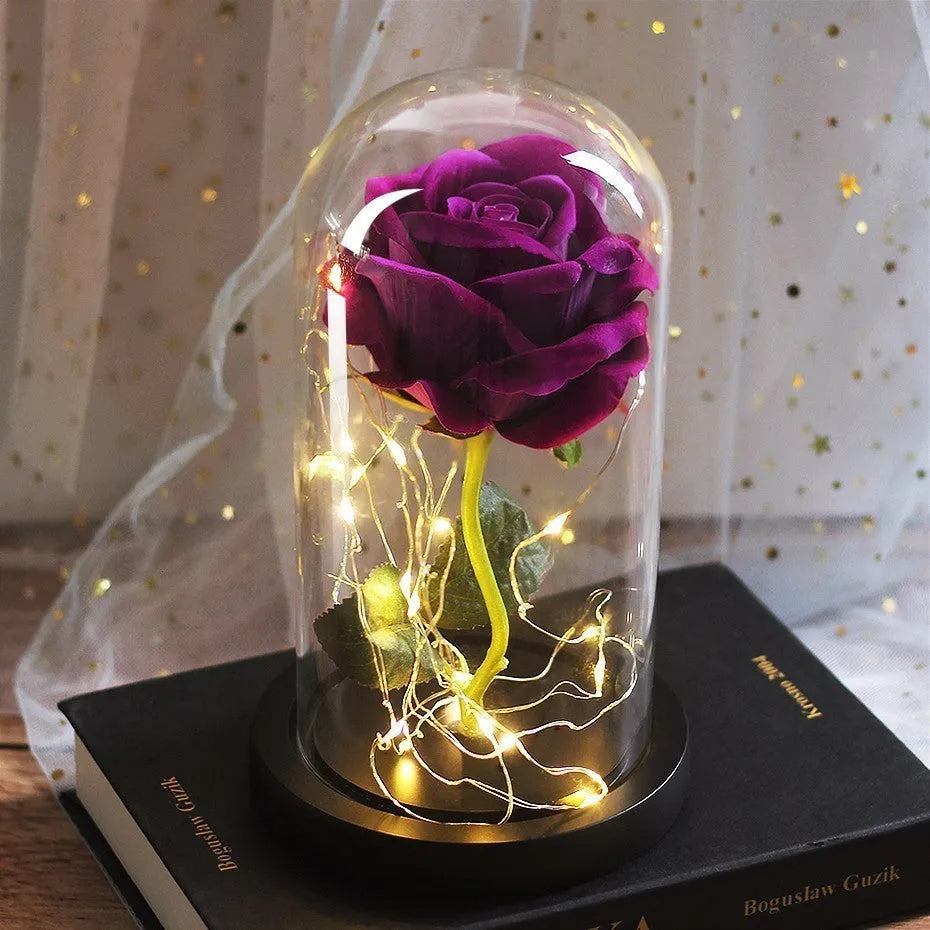 LED silk rose bouquet with glass lampshade glowing with warm white light on a solid wood base.