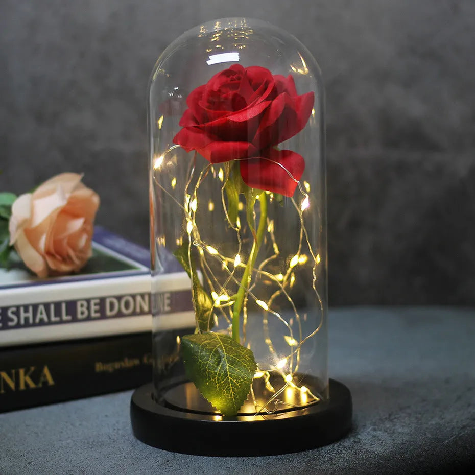 LED silk rose bouquet with glass lampshade glowing with warm white light on a solid wood base.
