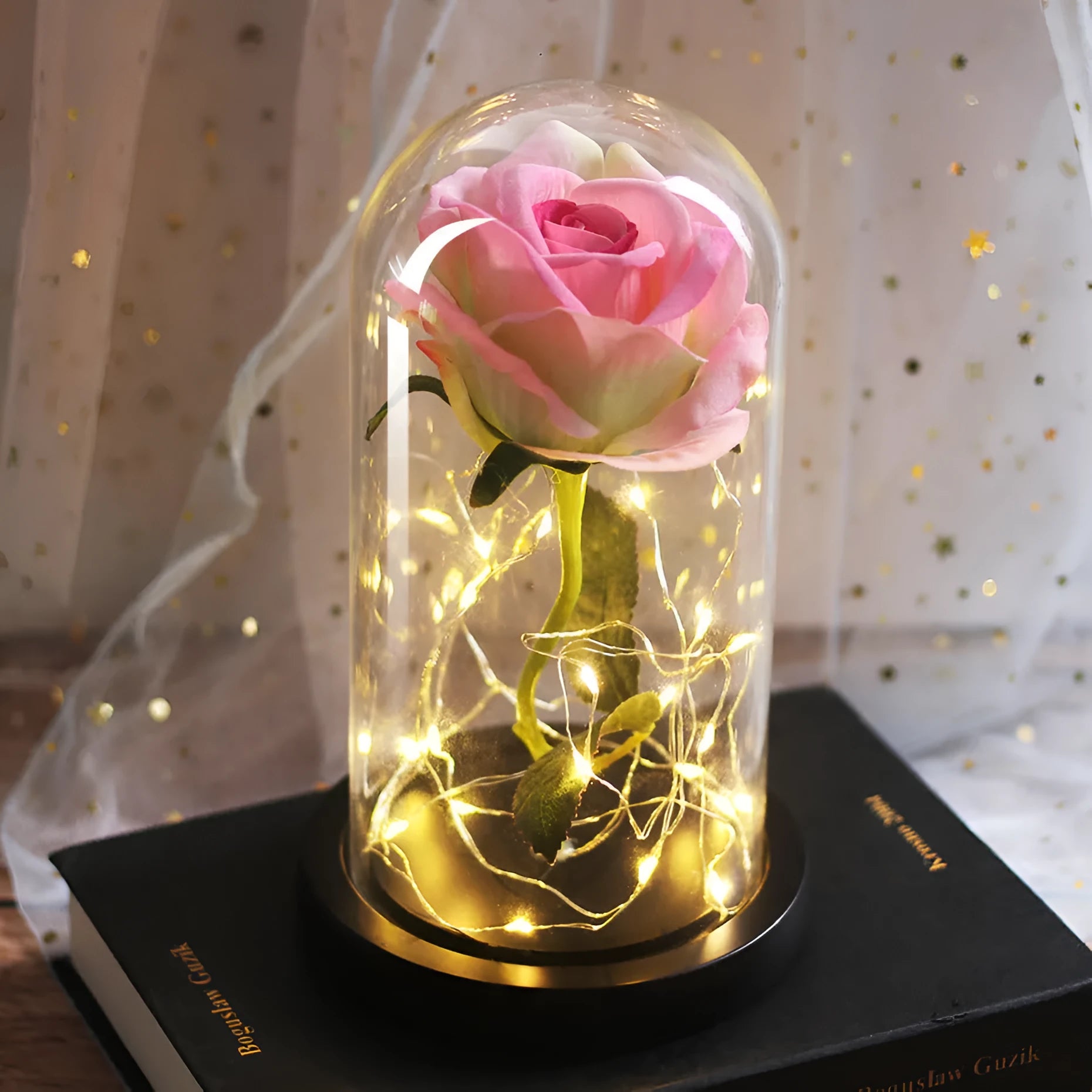 LED silk rose bouquet with glass lampshade glowing with warm white light on a solid wood base.