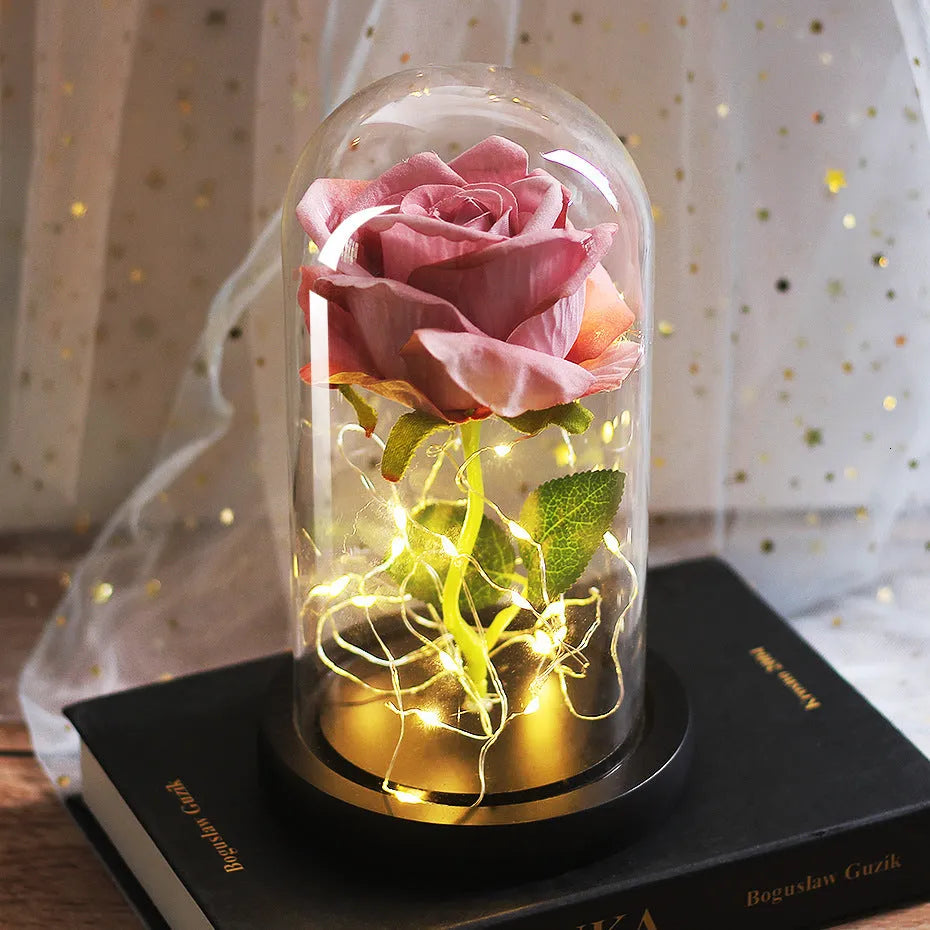 LED silk rose bouquet with glass lampshade glowing with warm white light on a solid wood base.