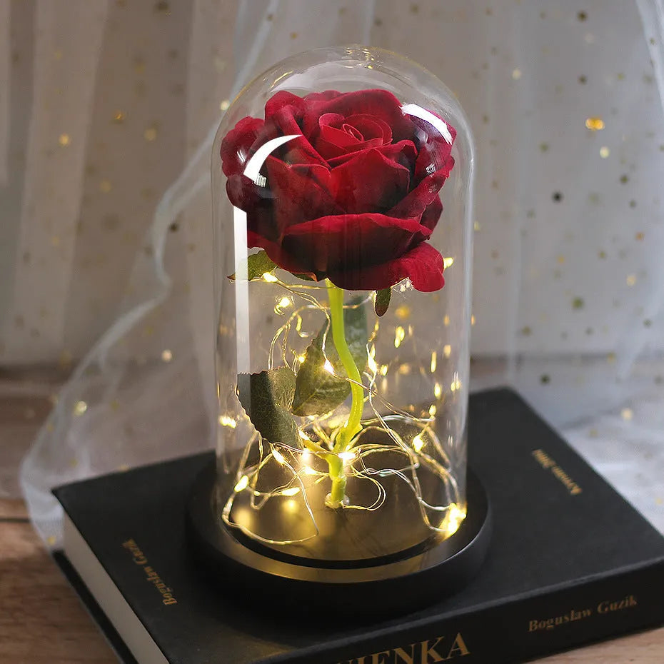 LED silk rose bouquet with glass lampshade glowing with warm white light on a solid wood base.