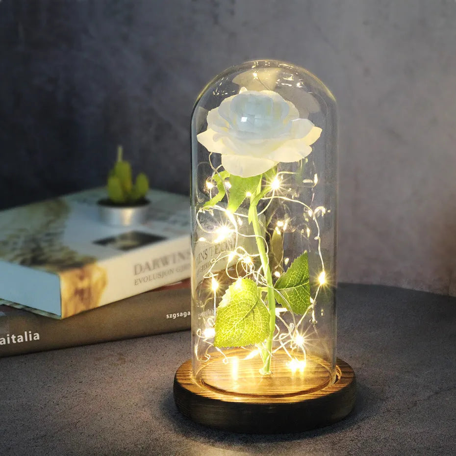 LED silk rose bouquet with glass lampshade glowing with warm white light on a solid wood base.