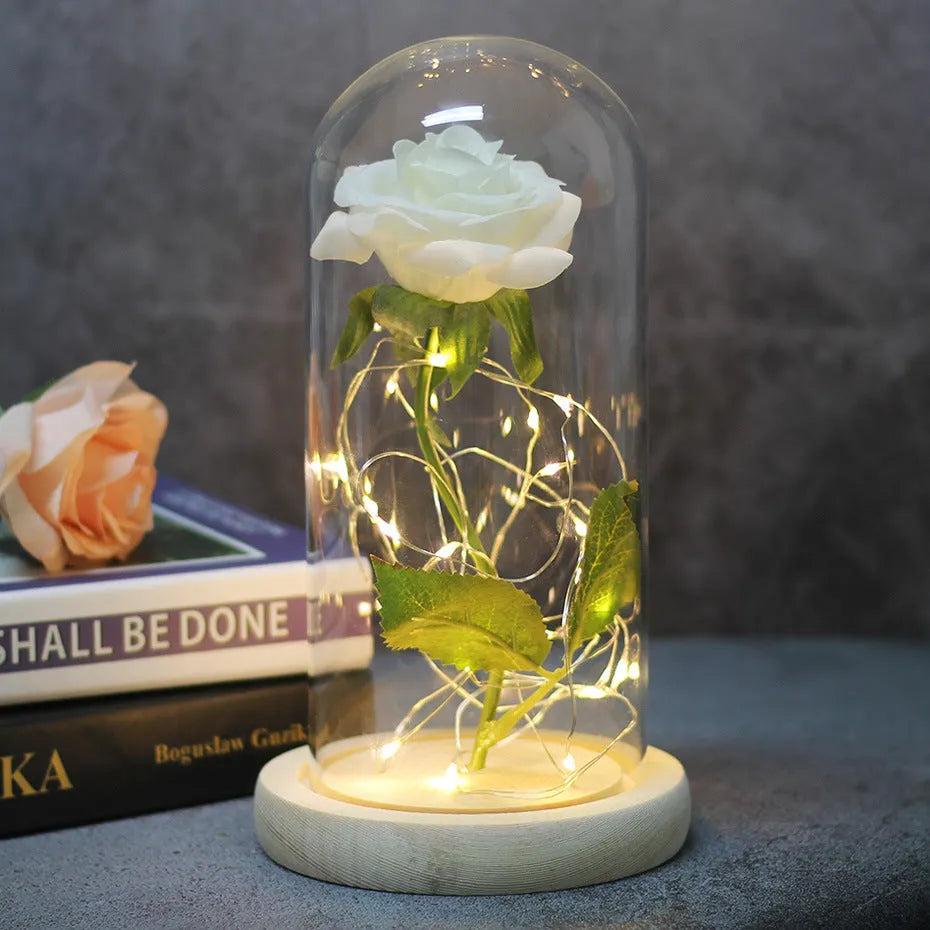 LED silk rose bouquet with glass lampshade glowing with warm white light on a solid wood base.