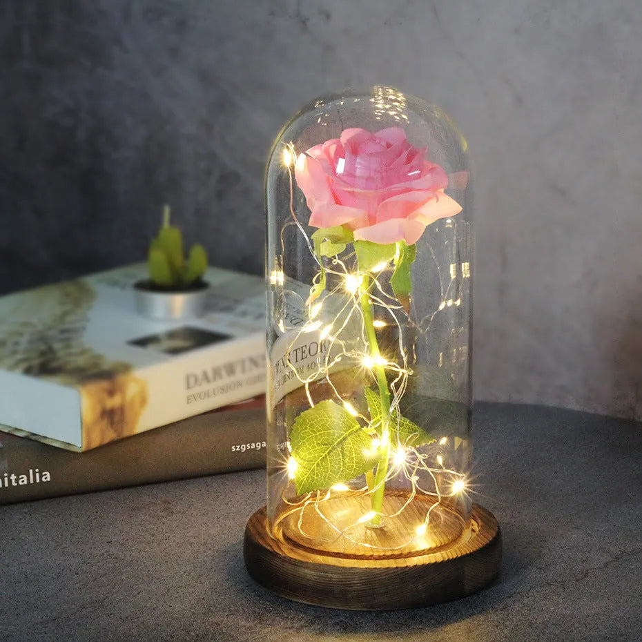 LED silk rose bouquet with glass lampshade glowing with warm white light on a solid wood base.