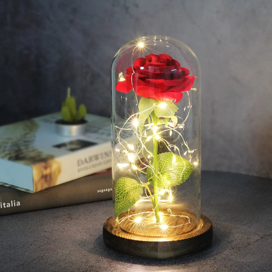 LED silk rose bouquet with glass lampshade glowing with warm white light on a solid wood base.