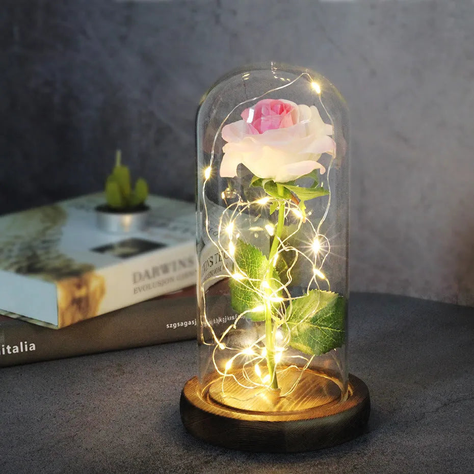 LED silk rose bouquet with glass lampshade glowing with warm white light on a solid wood base.