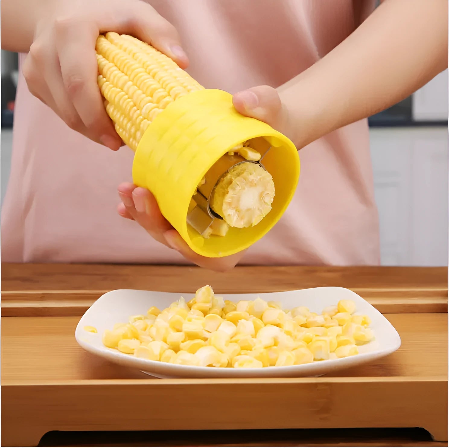 Yellow corn-shaped manual corn grinder thresher kitchen gadget on a wooden surface