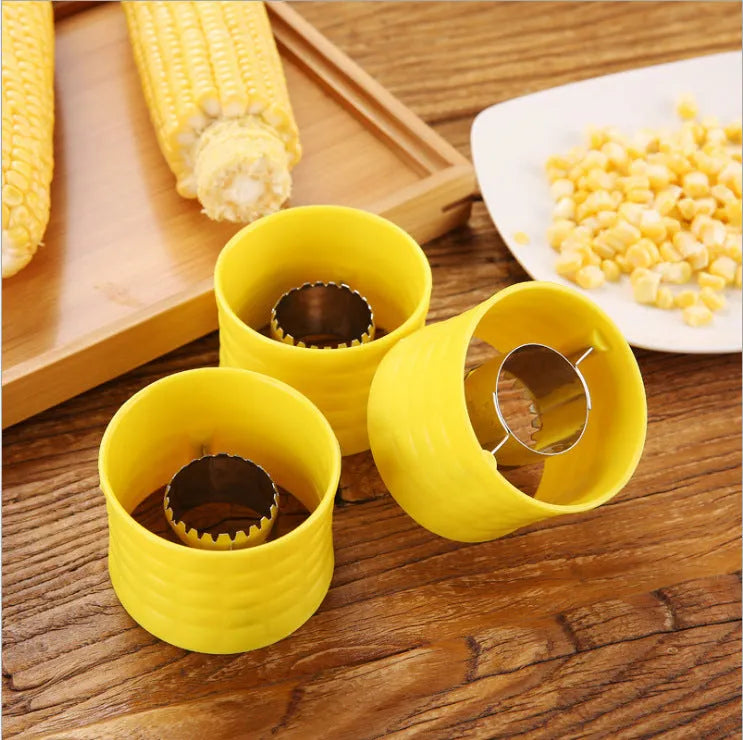 Yellow corn-shaped manual corn grinder thresher kitchen gadget on a wooden surface