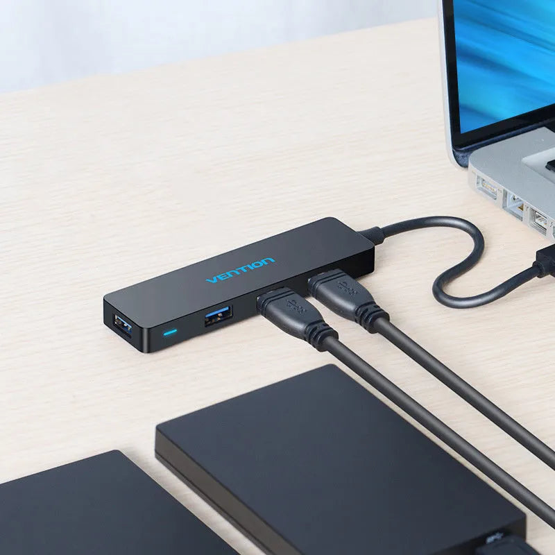 Black four-port USB 3.0 hub with a short 0.15m cable connected to a laptop