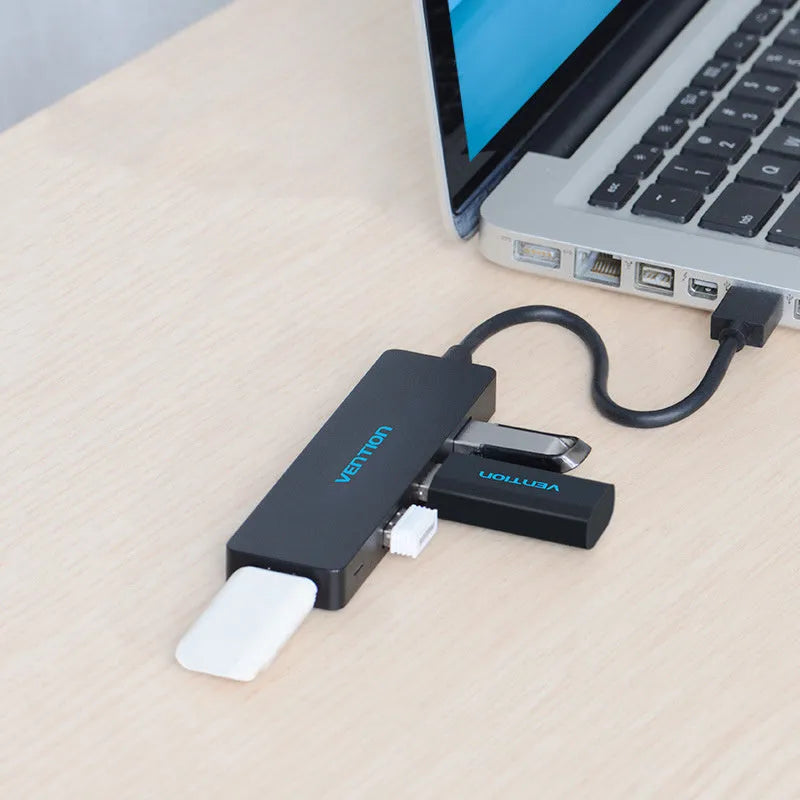 Black four-port USB 3.0 hub with a short 0.15m cable connected to a laptop