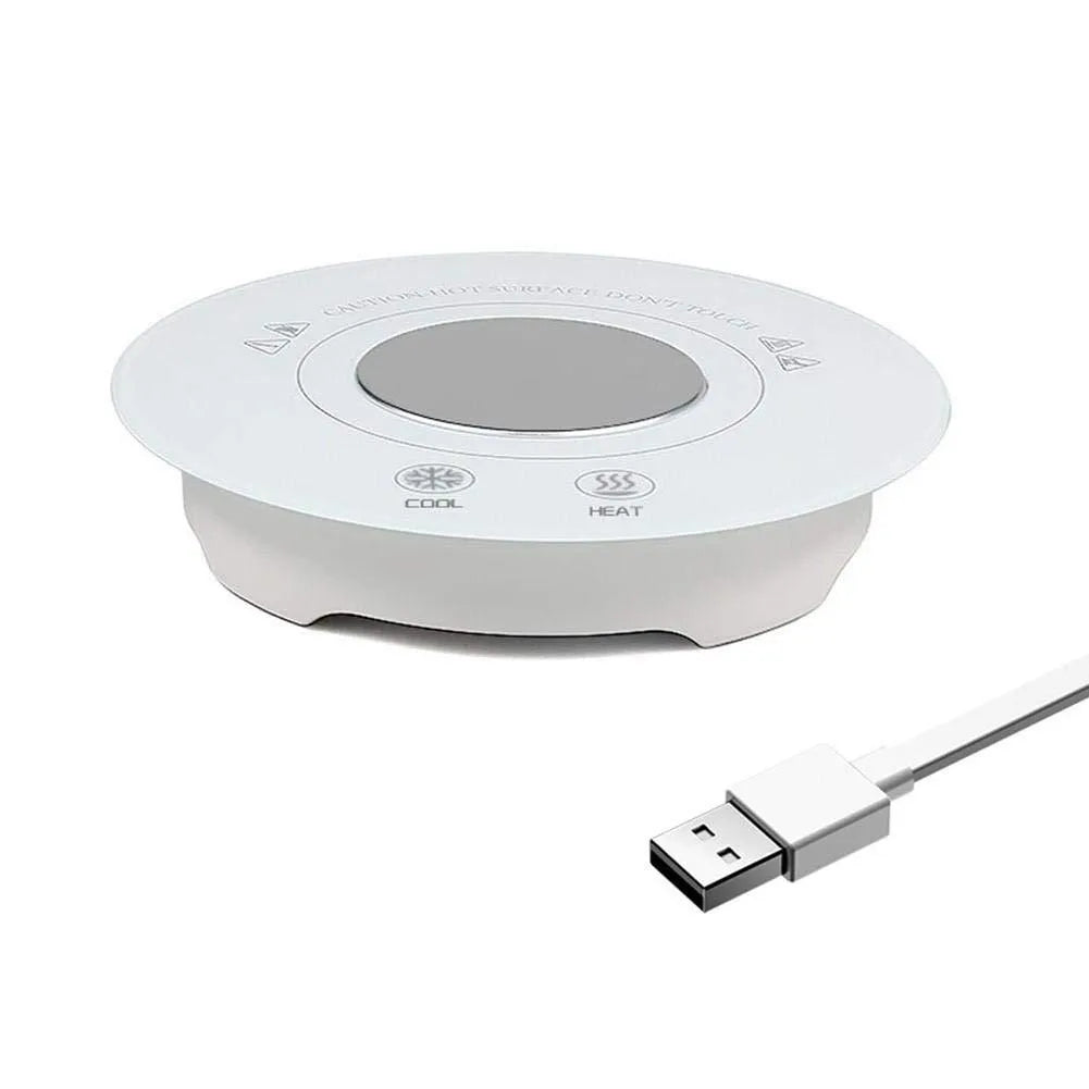 Black USB-powered hot and cold coaster for drinks on a desk next to a coffee cup.