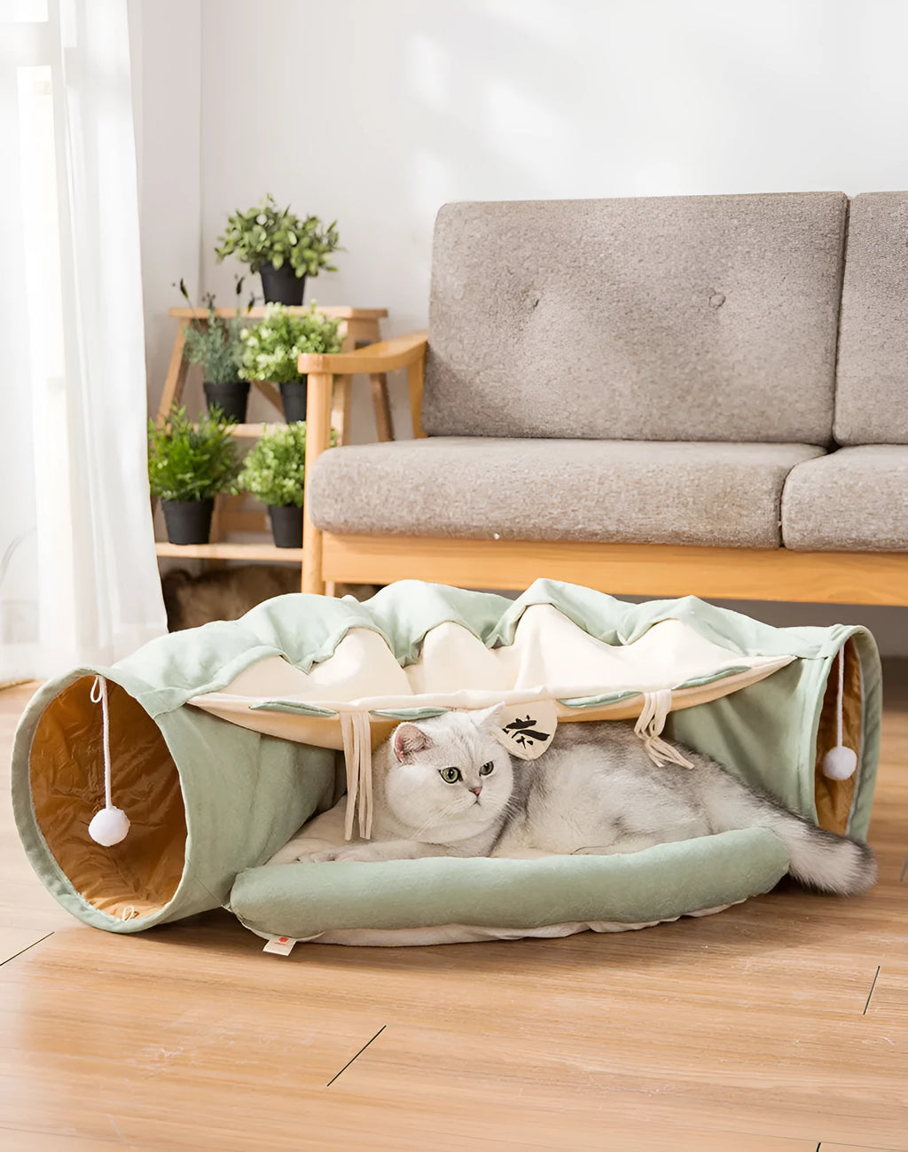 Collapsible cloth cat tunnel folded flat next to a cat, showing Coffee colour option.