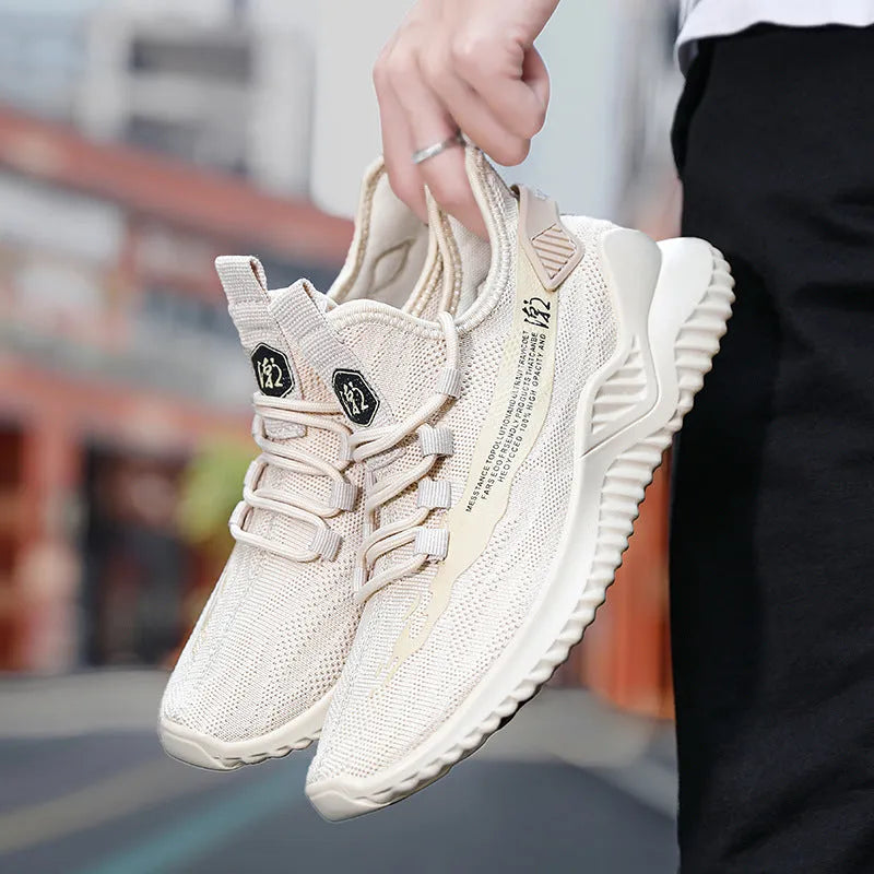 Men's low-top white mesh sports shoes with a rubber sole on a plain background.