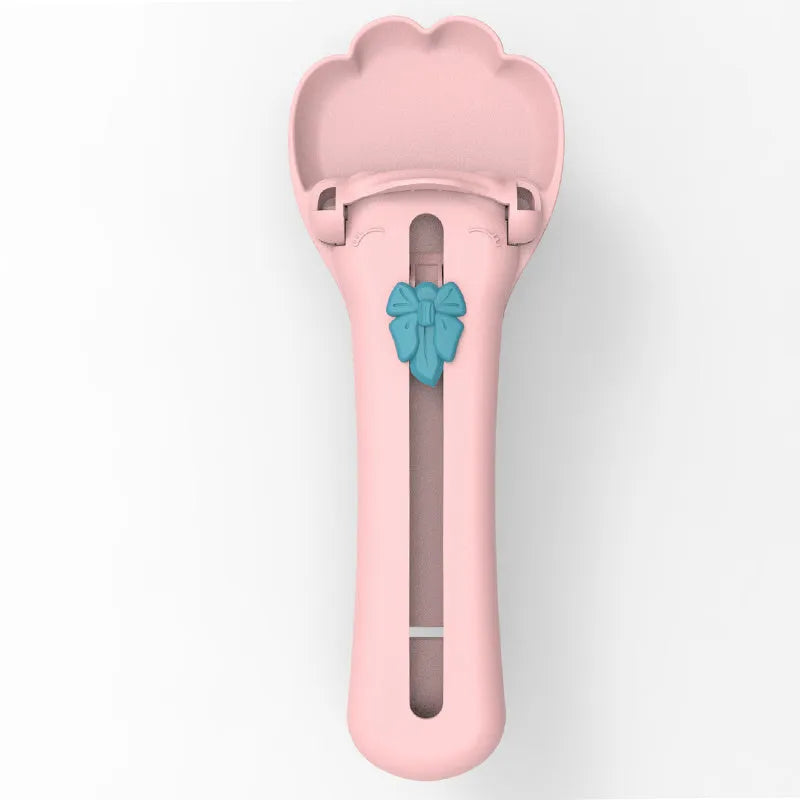 Green and pink two-tone plastic pet food extrusion spoon, 15cm long.