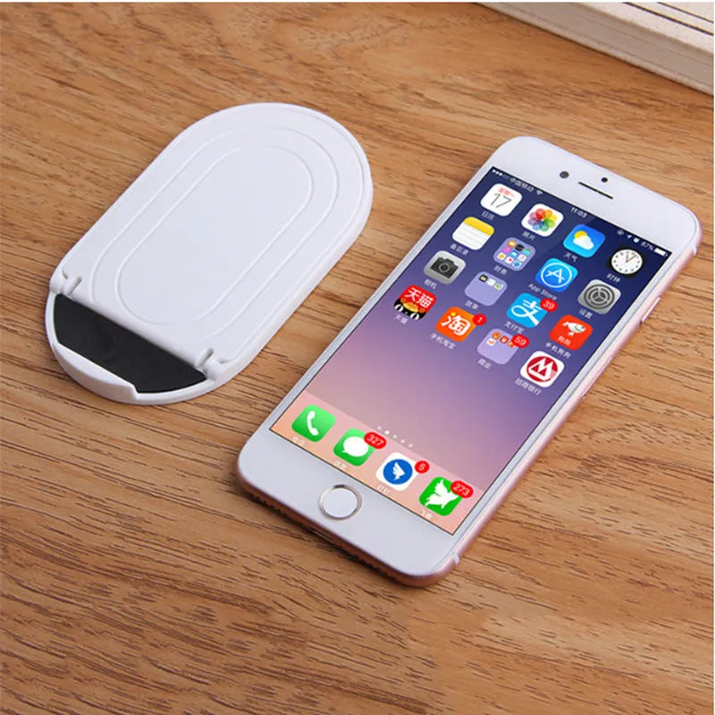 Adjustable plastic mobile phone stand in various colours holding a smartphone