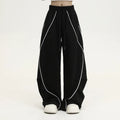 Black and white striped pleated wide-leg hip hop sports pants on a mannequin, showing loose fit and mid waist.