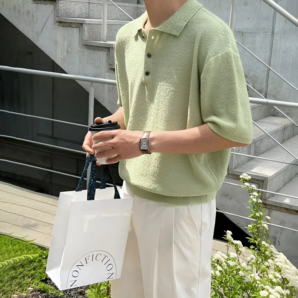 Man wearing a caramel-coloured loose-fit knitted polo shirt with short sleeves and an asymmetrical design detail.