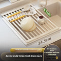 Foldable milky white stainless steel kitchen draining rack shown extended over a sink.