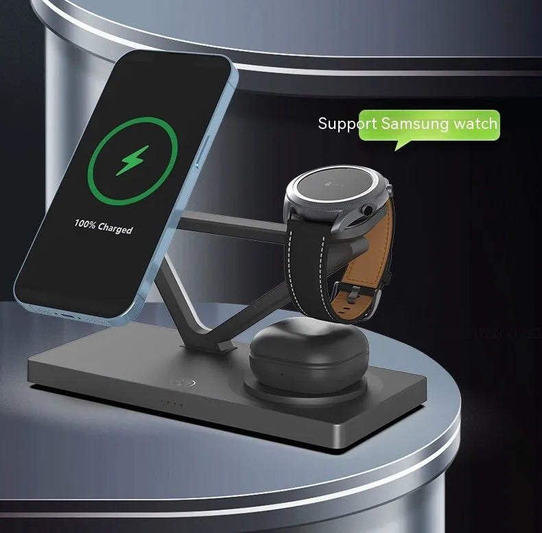 White 5-in-1 wireless charging station with magnetic phone holder, smartwatch pad, and glowing RGB night light on a wooden desk.
