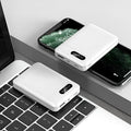 Black and white portable power bank with multiple capacity options and USB ports on a grey background.
