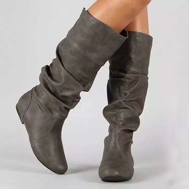 Women's black slip-on flat high cylinder boots with a round toe and rubber sole.
