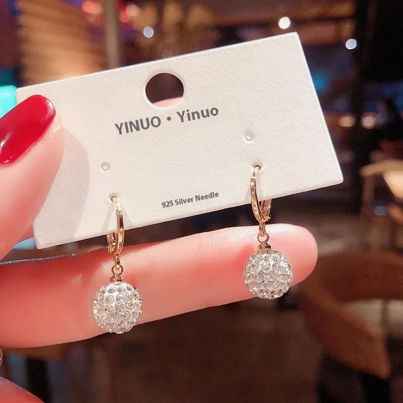 A pair of women's geometric rose design earrings in electroplated copper with zircon detail.