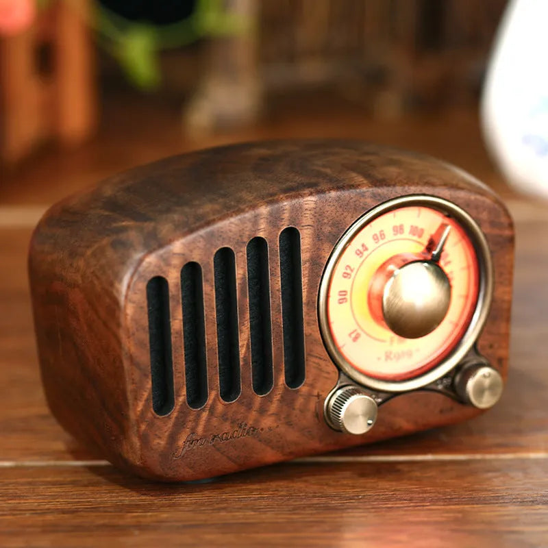 Retro wooden wireless mini Bluetooth speaker in cherry wood finish showing front speaker grille and controls