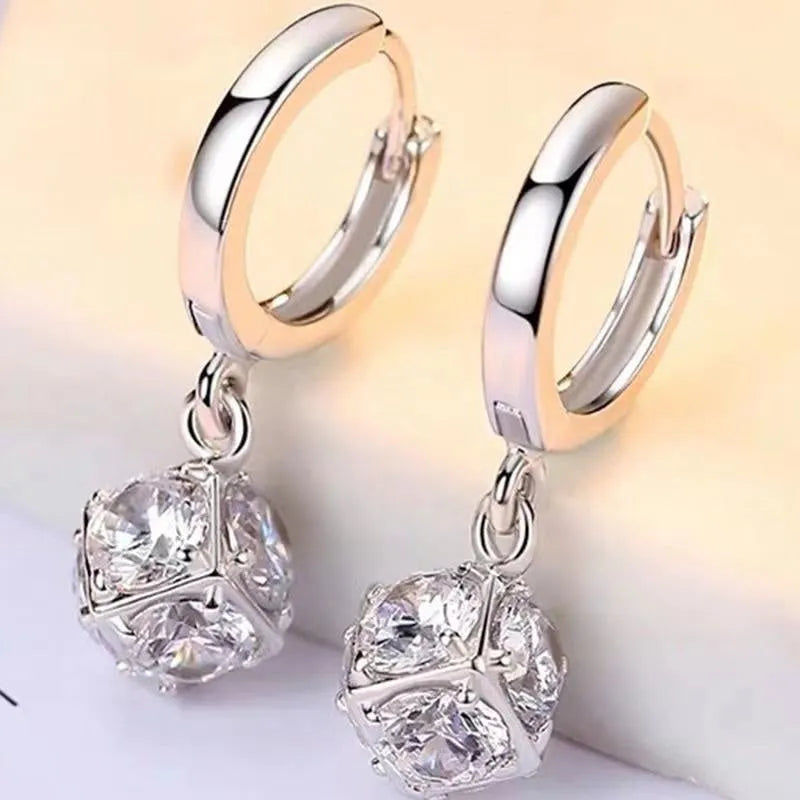 A pair of women's geometric rose design earrings in electroplated copper with zircon detail.
