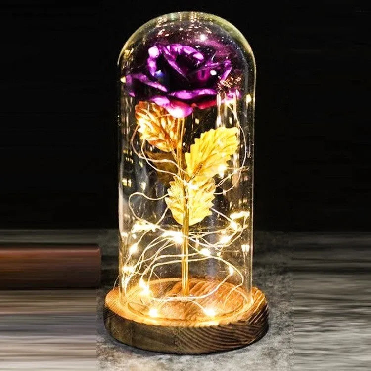 LED silk rose bouquet with glass lampshade glowing with warm white light on a solid wood base.