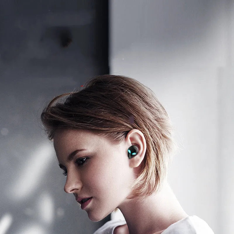 Alien-design T8 Starman Bluetooth headphones in charging case on white background
