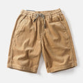 Men's khaki cargo shorts with multiple pockets showing straight leg fit