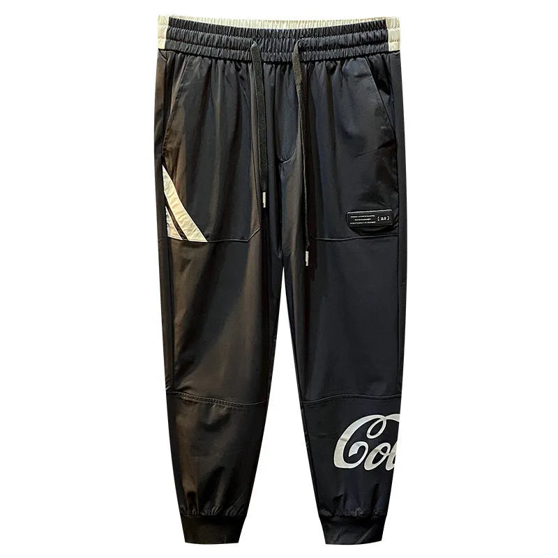 Men's black ice silk ankle banded cropped casual trousers on a plain background.